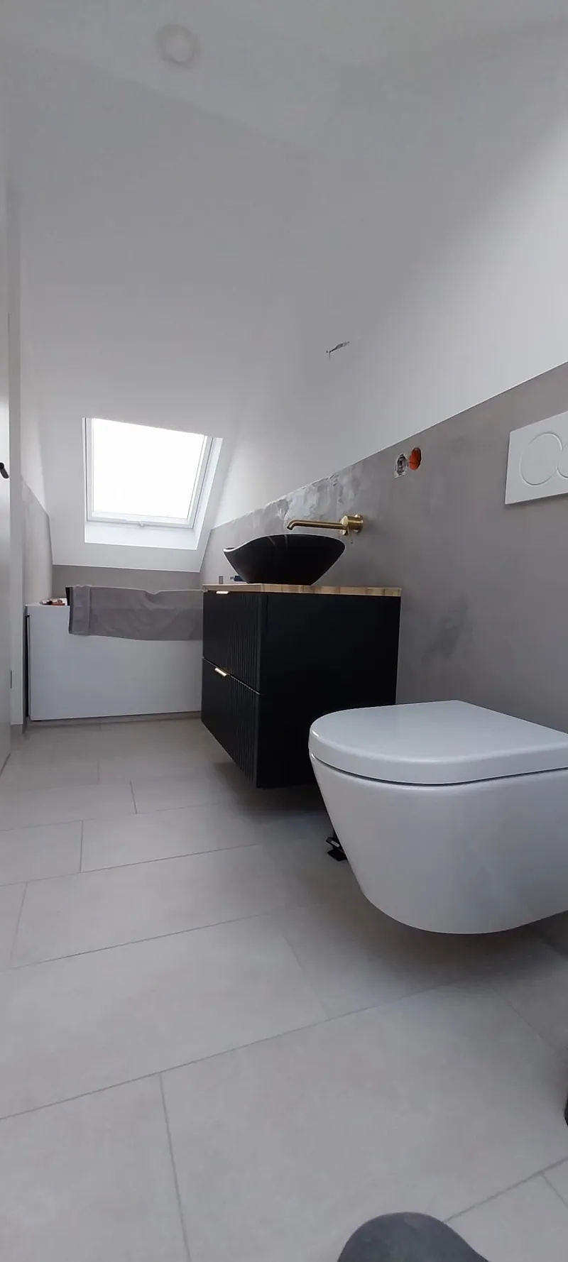 Dachgeschossbad mit hellgrauen großformatigen Bodenfliesen und Wand-WC