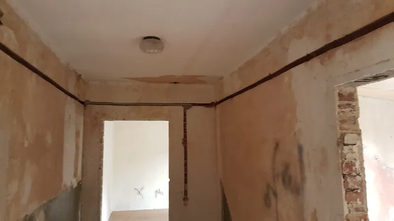 Flur im Altbau mit gestemmten Leitungsschlitzen an Wand und Decke