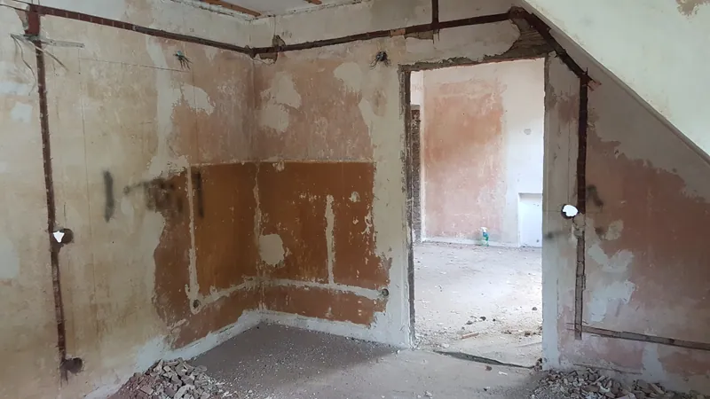 Dachgeschossraum mit Leitungsschlitzen, Unterputzdosen und Bauschutt