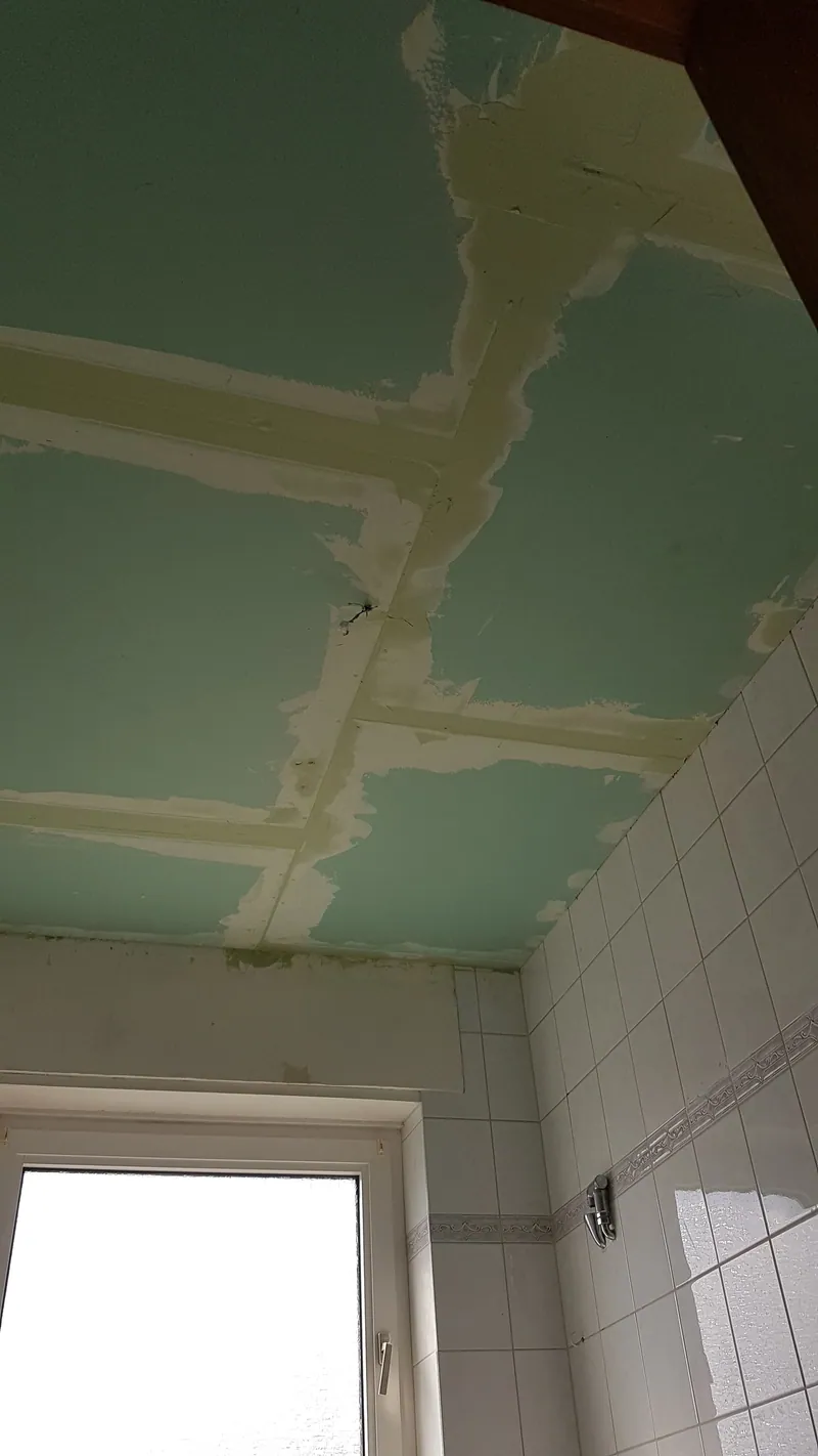Decke aus grünen imprägnierten Gipskartonplatten mit gespachtelten Fugen über einem gefliesten Bad