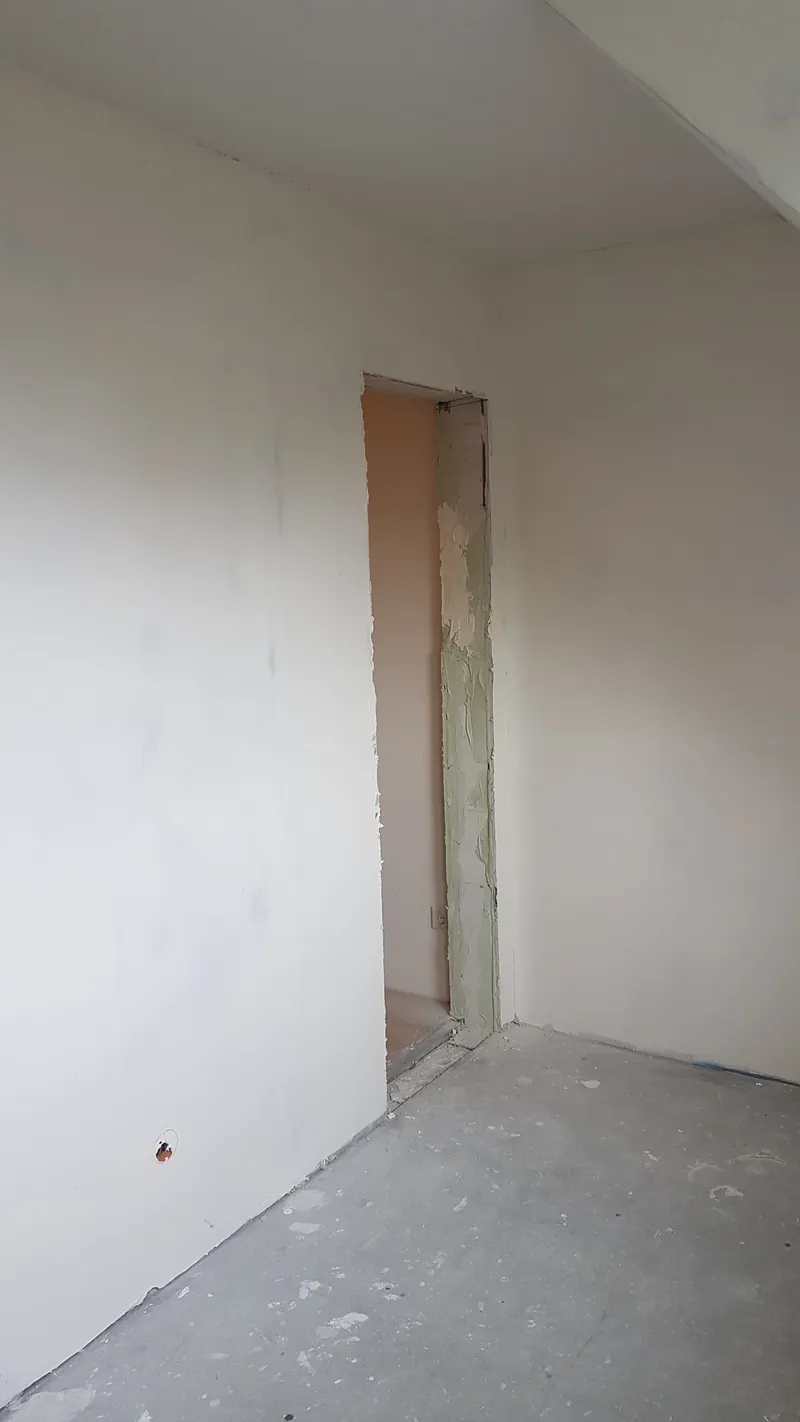 Trockenbauwand mit Türöffnung im Dachgeschoss, Spachtelung und Boden grau