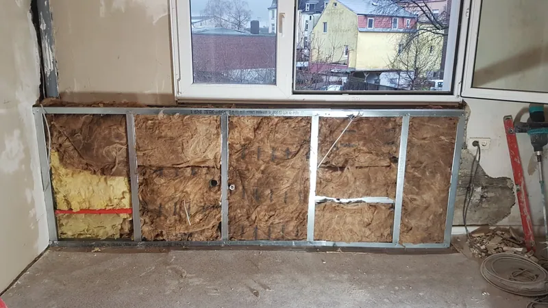 Trockenbauverkleidung unter dem Fenster mit Metallprofilen und Dämmwolle, noch offen