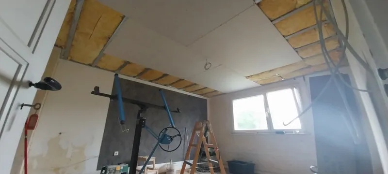 Abgehängte Decke im Entstehen mit Metallprofilen und Dämmwolle in einem Wohnraum