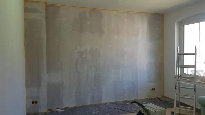 Raumhohe Trockenbauwand mit gespachtelten Fugen neben einem Fenster