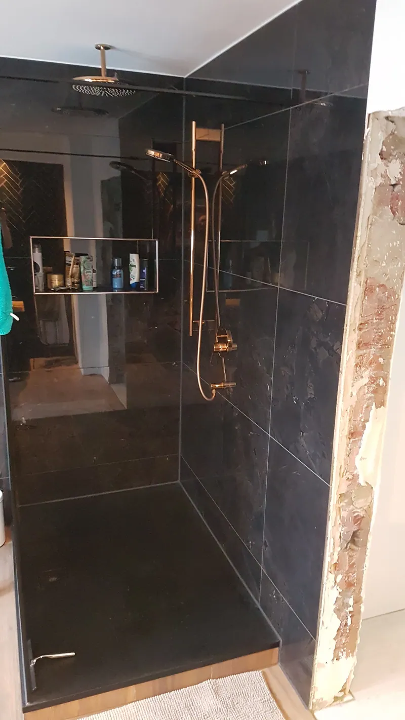 Dusche mit großformatigen dunklen Wandfliesen und Nische, Armaturen in Gold