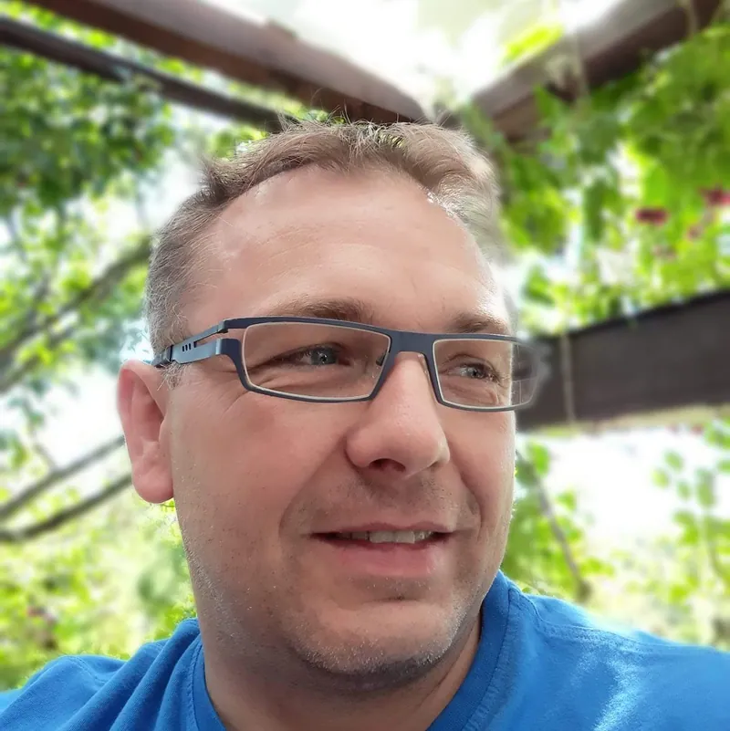 Artur Zakrzewski, Inhaber von ZAART Fliesen, lächelnd unter einer Pergola